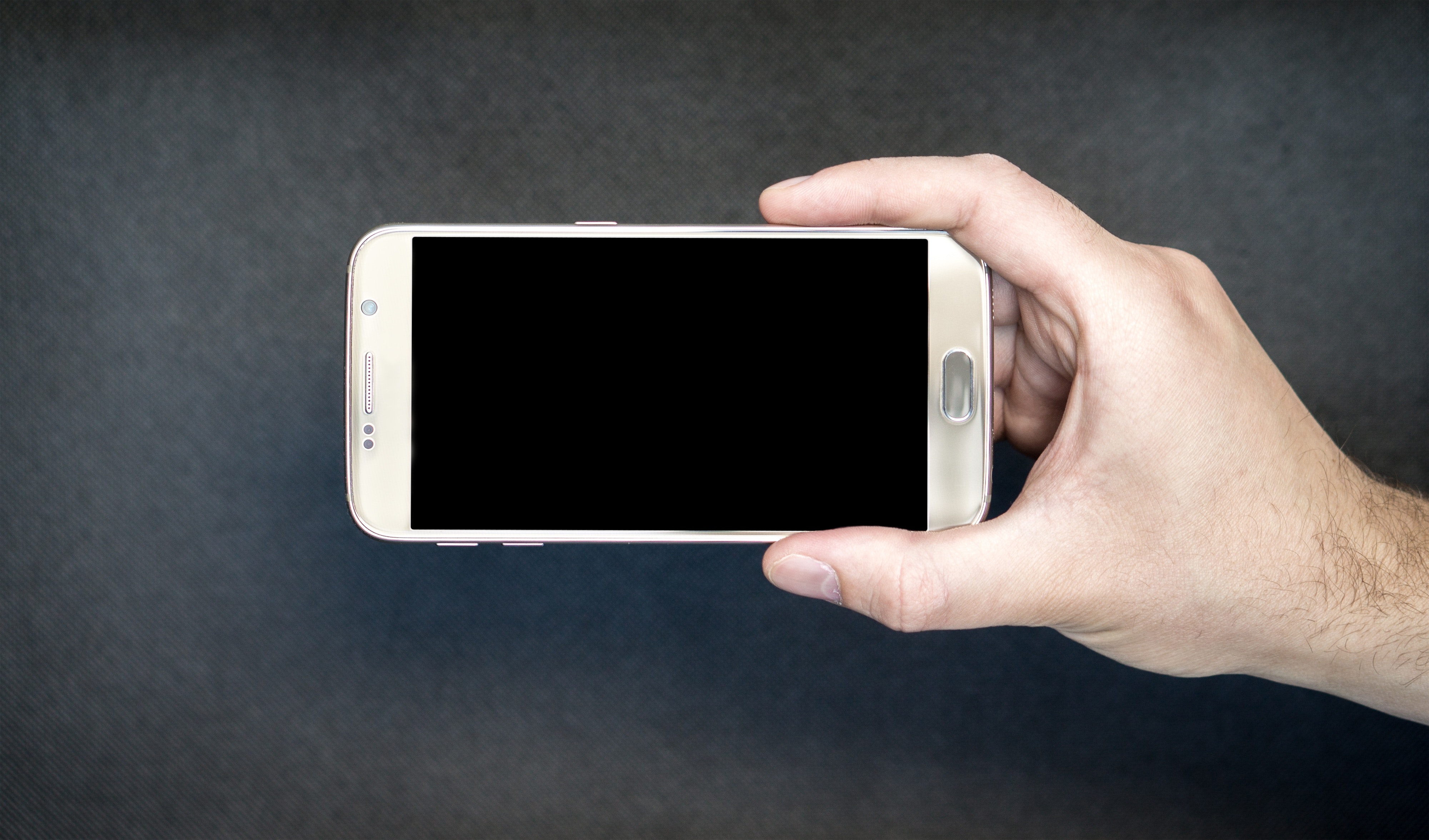 person holding their android with black screen